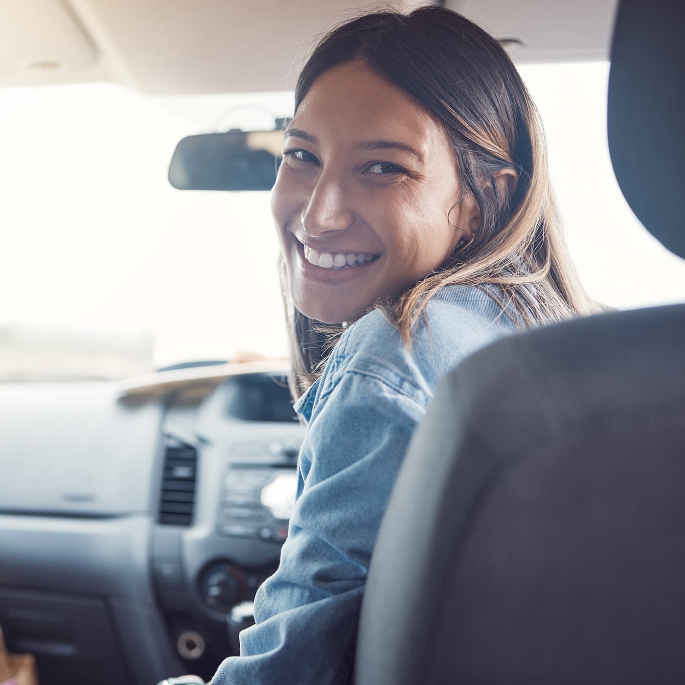 Female driver smiling in her car. Female driver smiling in her car.